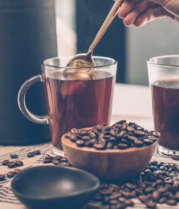 Coffee in glass mug with beans